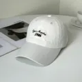 Detailansicht einer minimalistischen weißen Baseballkappe mit Los Angeles 1986 Stickerei - Los Angeles 1986 Stickerei Stil / Beige