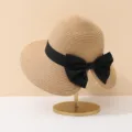 Vue détaillée d'un élégant chapeau de paille avec un ruban et un grand nœud noir décoratif - Style Nœud / Kaki