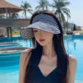 Stylish close-up of a woman wearing a blue and white striped sun visor by a resort pool - Adult 55-58cm / Striped Navy Blue