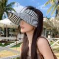 Model wearing a stylish black and white striped visor hat in sunny outdoors - Adult 55-58cm / Striped Black