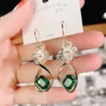 Macro close-up of elegant flower earrings with green crystal and 925 silver needle pins. - Geometric Emerald Style (E2494) / Green