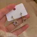 Detailed view of sparkling crystal flower dangle earrings in a warm gold finish. - Gold Rhinestone Floral (E1369)