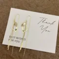 Detailed view of gold geometric tassel threader earrings with YES letter engraving. - Geometric Rhombus Letter Tassel Style (5369) / Gold
