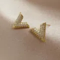 Close-up of elegant gold-toned V-shaped stud earrings paved with sparkling crystals - V-shaped Rhinestone Stud Earrings (E1379) / Gold