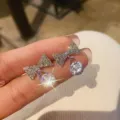 Close-up detail of sparkling silver bowknot earrings with teardrop crystal pendant - Bowknot Teardrop Pendant Stud Earrings (E1385) / Silver