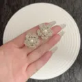 Elegante handgehaltene weiße Blumenohrringe aus Perlen mit einer Perle in der Mitte. - Handgewebte Blumen Perlenohrringe (E5003) / Silber