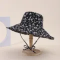 Detailed view of black and white floral print sun hat with wide brim and bow strap - Adult 55-58cm / Black with White Floral (6)
