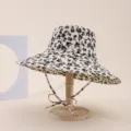 Elegant floral print sun hat featuring a wide brim and chin strap on a wooden stand - Adult 55-58cm / Beige with Black Floral (4)