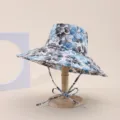 Macro view of blue floral print sun hat with large brim on a wooden display stand - Adult 55-58cm / Blue Gray Leaf Print (9)