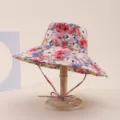 Detailed view of a colorful floral print sun hat with a wide brim on a wooden display stand - Adult 55-58cm / Multicolor Floral Print (10)