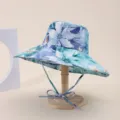 Detailed view of a blue floral print wide-brimmed sun hat on a natural wooden stand - Adult 55-58cm / Blue-Green Floral Print (20)