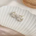Elegant white bow stud earrings with small pearls displayed on a white shell tray - Bow Pearl Circle Stud Earrings (E3830) / White