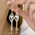 Detailed close-up of elegant gold geometric pearl earrings with long delicate fringe tassels - Hollow Rhombus Pearl Tassel Earrings (E2531) / Gold