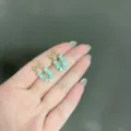 Elegant mint green beaded U-shaped earrings with gold-toned hardware on a hand - U-Shaped Beaded Stud Style (E2331 Gold) / E2331 Gold