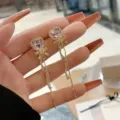 Elegant pink heart-shaped earrings with crystal bow and long tassels held in hand. - Pink Heart Bow Long Tassel Style (E3110) / Gold Pink