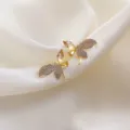 Elegant gold-toned dragonfly stud earrings with yellow crystals on white satin background - Dragonfly Design Rhinestone Stud Earrings (E1383) / Gold