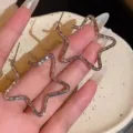 Close-up of large star-shaped textured hoop earrings for women, gold tone finish. - Hollow Pentagram Style (E4844) / Silver