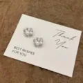 Detailaufnahme der silbernen gedrehten Blumenohrstecker mit einer Perle auf einer Karte. - Feiner Draht Hohle Blume Künstliche Perle Stil (E5378) / Silber