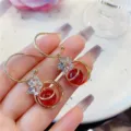 Elegant golden hoop drop earrings with red bead and sparkling crystal flower detail - Crystal Floral Red Gold (E1201)
