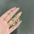 Elegant gold-tone geometric long drop earrings featuring a unique textured oval center piece - Geometric Rhombus Long Drop Earrings (E1387) / Gold