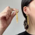 Elegante goldene Quasten-Blumenohrringe mit Kristallakzenten an einem Model. - Französischer Quasten Stil (E5409) / Gold Kristall Quaste (E5409)