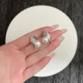Boucles d'oreilles en métal brossé argenté avec perle blanche, design créatif épuré. - Boucles d'Oreilles Clous Perle Enveloppée en Métal Brossé (E5018) / Argent