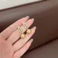 Elegant golden pearl drop earrings with a sparkling rhinestone geometric top design. - Champagne Rhinestone Artificial Pearl Dangle Style (E1334) / Gold