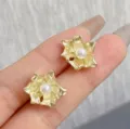 Elegant vintage gold-tone flower petal stud earrings with central pearl detail on hand - Pearl Flower Stud Earrings (E4649) / Gold