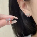 Elegant silver bow stud earrings shown on model ear for jewelry variant view - Vintage Bowknot Stud Earrings (E4686) / Silver