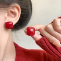Vintage red square glossy stud earrings shown on ear and held in hand - Glazed Square Style (E5062) / Red