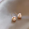 Detailaufnahme der französischen Knospen-Perlenohrringe auf champagnerfarbener Seide - Französischer Emaille Blütenknospe Künstliche Perle Stil (E5376) / Gold