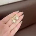 Eleganti orecchini color oro con grandi perle color crema e micro-cristalli pavé. - Stile Doppia Perla Grande Fiocco (E3682) / Oro champagne