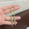 Elegant gold-toned long dangling earrings with shimmering rectangular crystal accents. - Geometric Tassel Style / Gold (E3275)