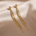 Elegant gold tassel drop earrings with textured metallic strips on silk background - Step Tassel Earrings (E3374) / Gold