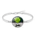 Detailed macro view of silver alloy bangle featuring a lucky green four-leaf clover glass gem - Lucky Clover Style 3 (XSWX6011-3)