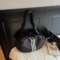 Black sports duffel bag with three white stripes, stylish large capacity travel shoulder bag. - Black