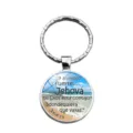 Close-up of circular metal keychain with Spanish Bible verse and beach background - Beach Joshua 1:9 (XSWX9324-4)