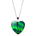 Detail of a heart-shaped necklace featuring a vivid green aurora borealis and forest print - Chain Style / Style 2 (XSWX9361-2)