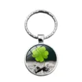 Close-up of a silver glass cabochon keychain with a lucky green four-leaf clover design. - Dewdrop Clover Style (XSWX6006-3)
