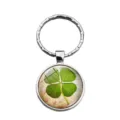 Close-up of a lucky four-leaf clover time gem keychain with vintage floral background - Floral Base Clover Style (XSWX6006-2)