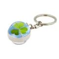 Close-up of a silver keychain pendant featuring a vibrant green clover under a crystal dome - Blue Sky Clover (XSWX6005-11)