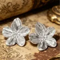 Nahaufnahme von silbernen Vintage-Ohrsteckern in Blumenform mit Textur. - Strahlendes Muster Vintage Blumenstecker (E5364) / Silber