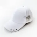 Detail of white punk style baseball cap featuring metal rings and edgy safety pin charms - Adjustable / Safety Pin Tools White