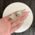 Detailansicht von 3D-Ohrsteckern in Blumenform mit schimmernden cremefarbenen Blüten - Schwarz Linien Gelb (E5044) / Gelb
