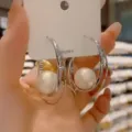 Vista detallada de elegantes pendientes de aro plateados de doble capa con perlas - Estilo Geométrico de Doble Capa (E5384) / Oro blanco