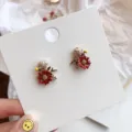 Macro detail of elegant forest style red flower stud earrings with sparkling rhinestones - Floral Stud Earrings / Red
