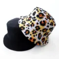 Detail view of reversible bucket hat, showing black and colorful leopard print sides clearly. - Adult 55-58cm / Yellow Leopard Print