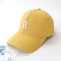 Detailed close-up view of a yellow baseball cap featuring a white embroidered letter R logo - Adult 55-59cm / Yellow