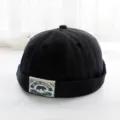 Detailansicht einer schwarzen retro docker mütze, trendiger melon hat mit vintage patch. - Erwachsene 55-58cm / Schwarz