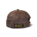 Detail view of brown corduroy brimless docker hat with a woven embroidered label - Adult 55-58cm / Coffee